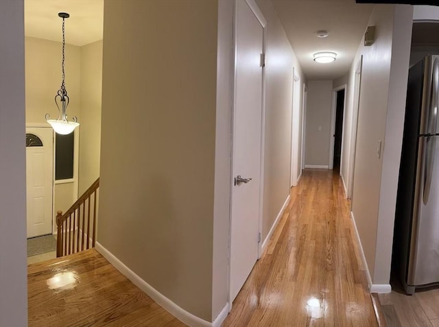 hallway with light wood-type flooring and baseboards