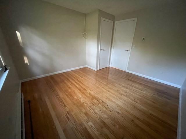 unfurnished room with wood finished floors and baseboards