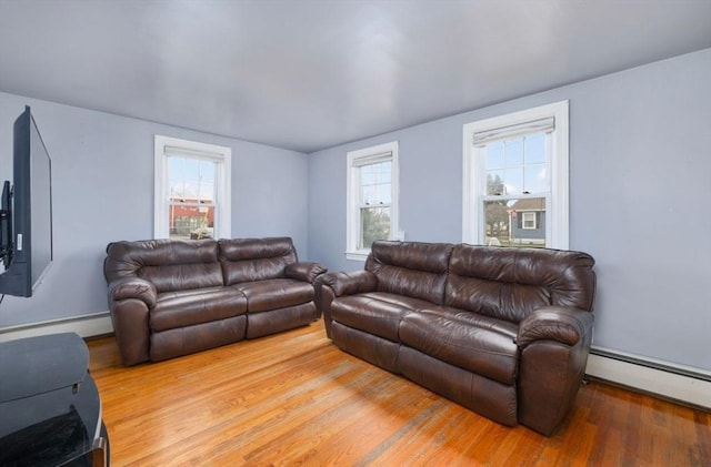 living room featuring plenty of natural light, wood-type flooring, and a baseboard radiator