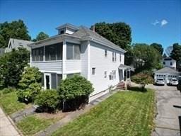 view of side of home with a lawn and a sunroom