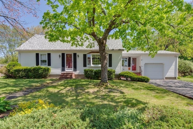 ranch-style home featuring a garage, asphalt driveway, a front lawn, and entry steps