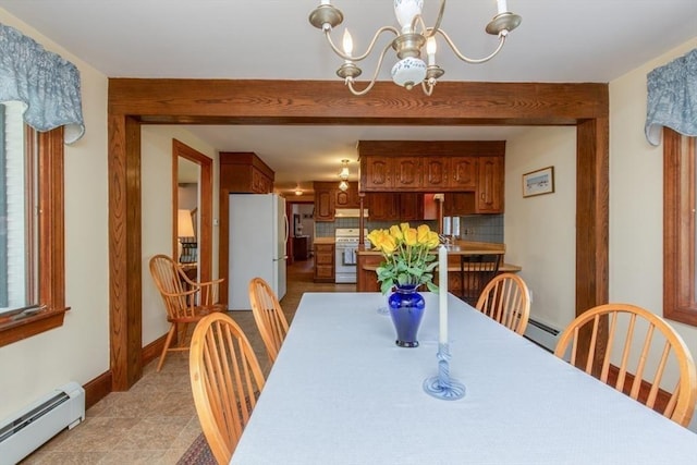 dining area with baseboard heating, a chandelier, and baseboards