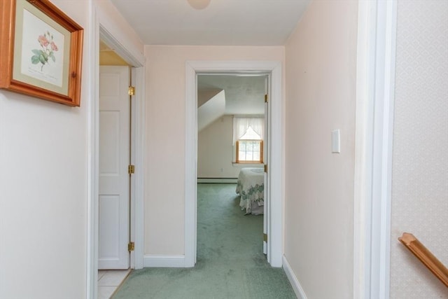 hallway featuring light colored carpet, a baseboard radiator, and baseboards