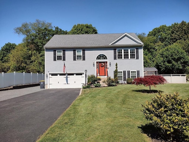 raised ranch with driveway and an attached garage