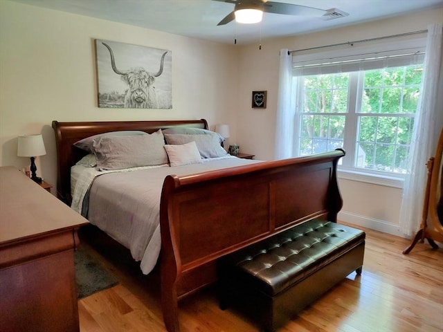 bedroom featuring light wood-style flooring, multiple windows, baseboards, and ceiling fan