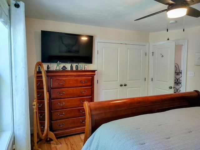 bedroom featuring a closet, light wood-style floors, and ceiling fan