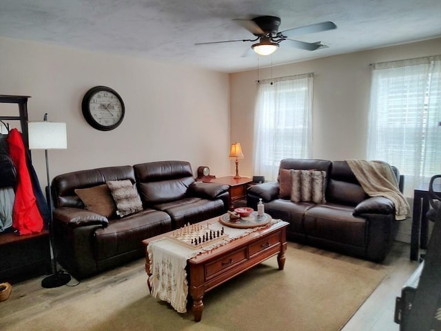 living area with a ceiling fan and light wood-style floors