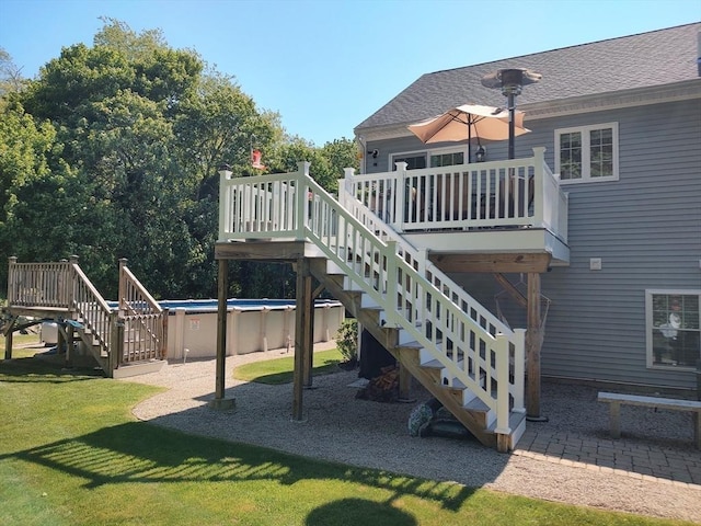 view of patio featuring stairs, a deck, and an outdoor pool
