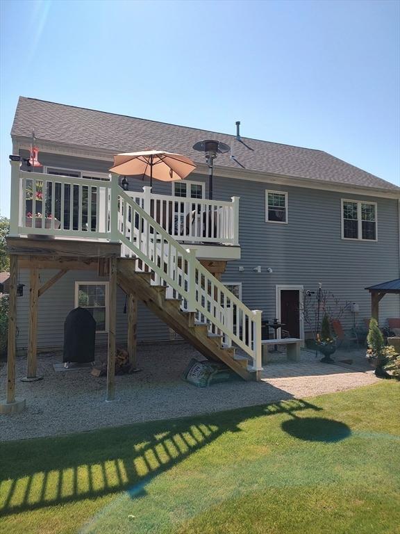 back of house featuring a lawn, a wooden deck, a patio, and stairway