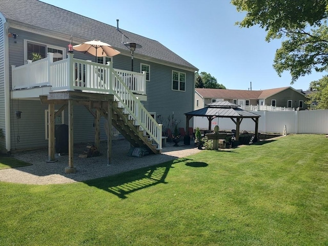 rear view of property featuring a gazebo, a wooden deck, stairway, and roof with shingles