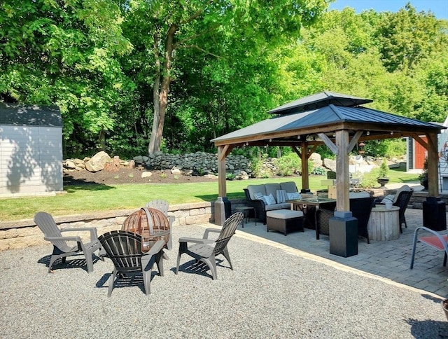 view of patio with a gazebo and an outdoor living space with a fire pit
