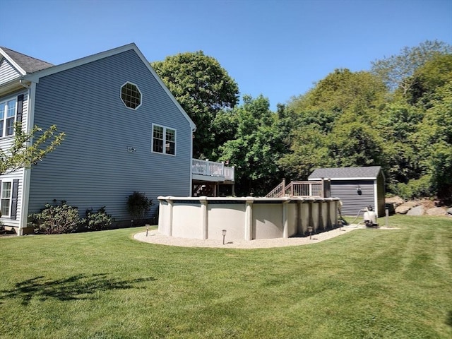 back of property featuring a yard, a shed, and an outdoor pool