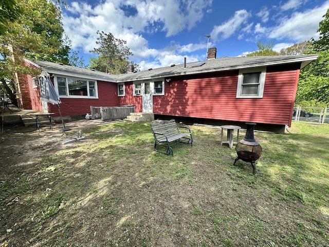 23 Rhodes Cir, Hingham, MA 02043 - rear view of house featuring an outdoor fire pit, a chimney, and a lawn
