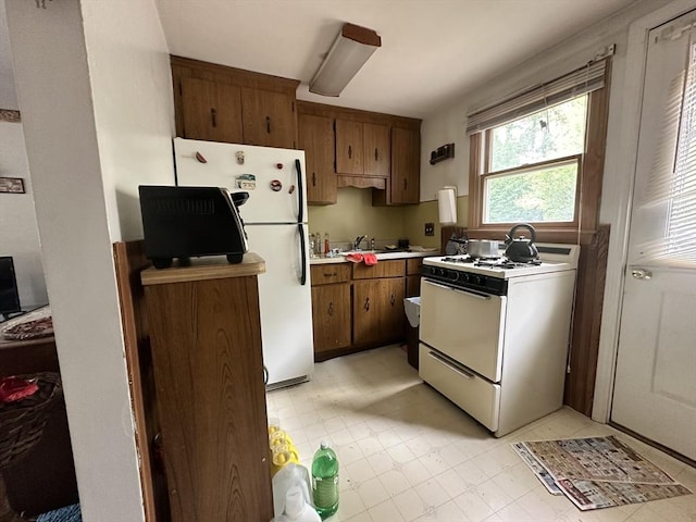 23 Rhodes Cir, Hingham, MA 02043 - kitchen with white appliances, light countertops, brown cabinetry, and a sink