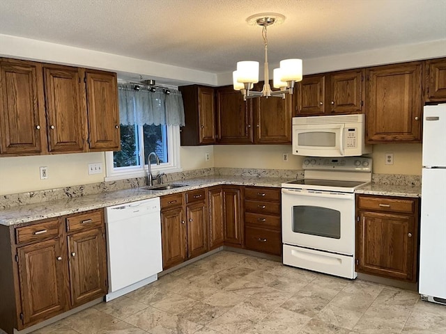 kitchen featuring a textured ceiling, white appliances, sink, a notable chandelier, and hanging light fixtures