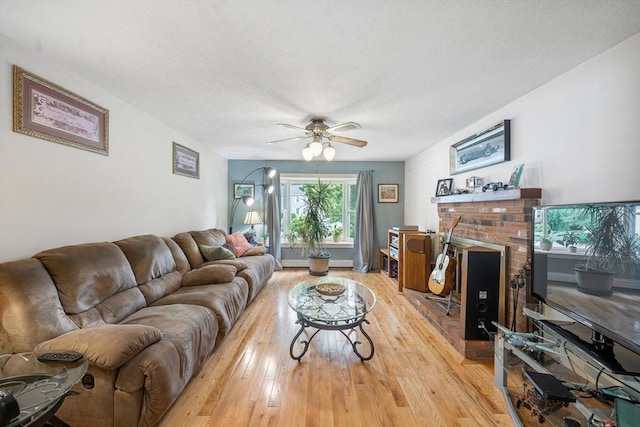 10 Manoogian Cir, Milford, MA 01757 - living room featuring light wood-style flooring, ceiling fan, a fireplace, and a textured ceiling