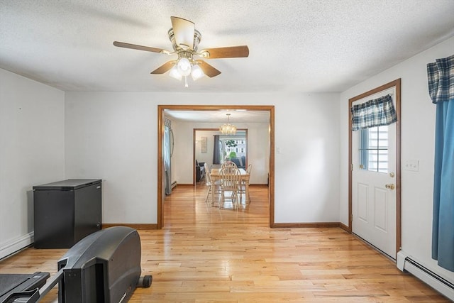 10 Manoogian Cir, Milford, MA 01757 - foyer entrance with a baseboard radiator, light wood finished floors, a textured ceiling, a ceiling fan, and a baseboard heating unit