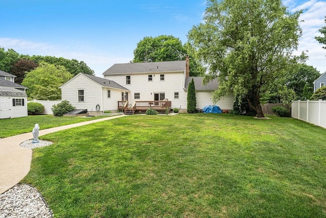 10 Manoogian Cir, Milford, MA 01757 - back of property with a wooden deck, a fenced backyard, and a chimney