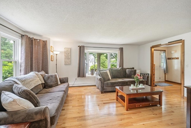 10 Manoogian Cir, Milford, MA 01757 - living area featuring healthy amount of natural light, a textured ceiling, light wood-type flooring, and a baseboard radiator