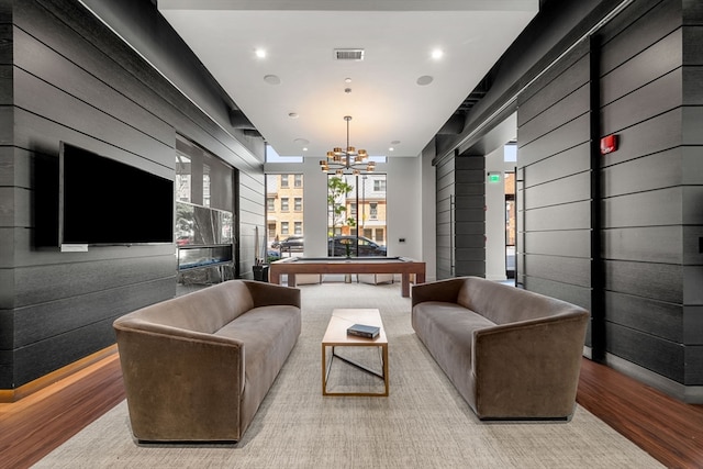 living room featuring a notable chandelier, wood-type flooring, and pool table