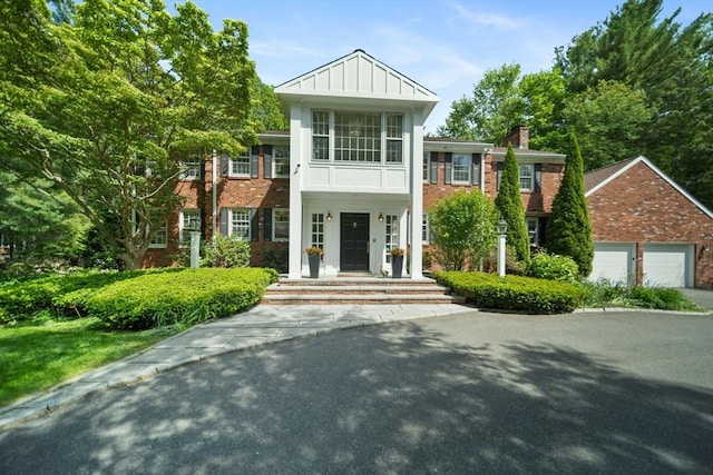 51 Canterbury Ln, Needham, MA 02492 - view of front of property featuring brick siding, a garage, and a chimney