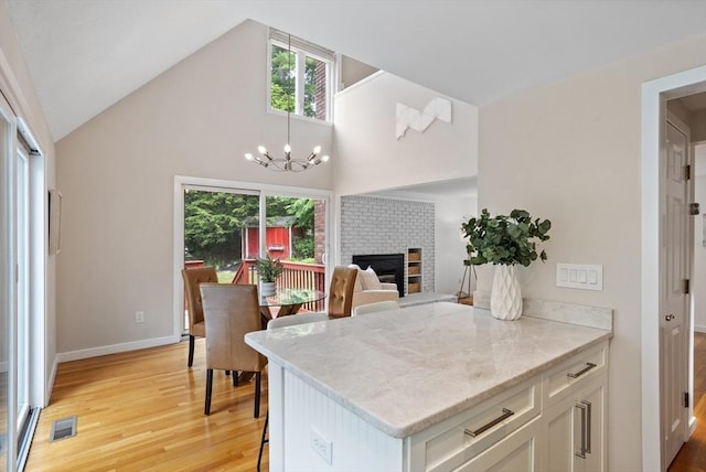 13 Long Ridge Rd, Acton, MA 01720 - kitchen with light wood finished floors, plenty of natural light, a chandelier, white cabinets, and high vaulted ceiling