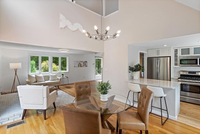 13 Long Ridge Rd, Acton, MA 01720 - dining space featuring a high ceiling, light wood-type flooring, and a chandelier