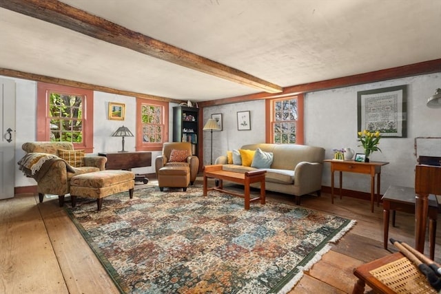 living area with light wood finished floors, healthy amount of natural light, and beam ceiling