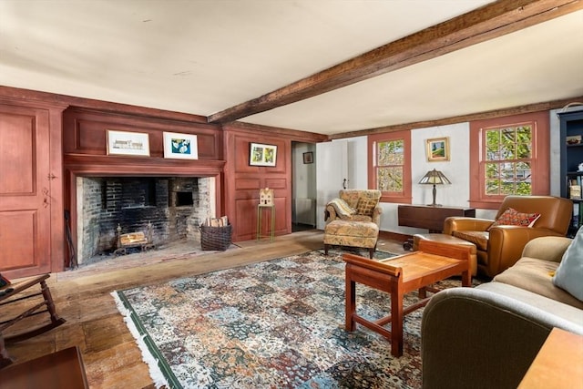 living area featuring wood finished floors, a fireplace with flush hearth, and beam ceiling