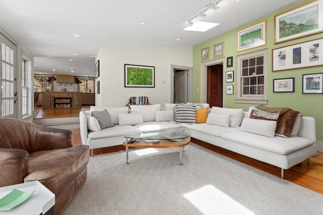 living area featuring recessed lighting, wood finished floors, and rail lighting