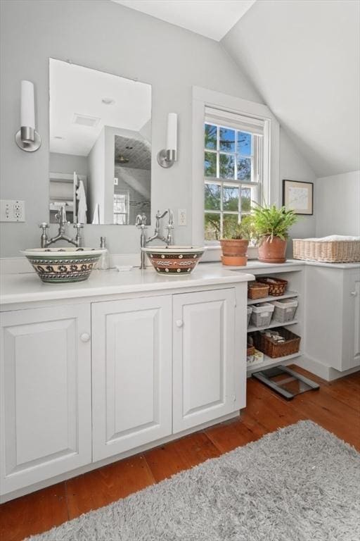 bathroom featuring vaulted ceiling, wood finished floors, and vanity