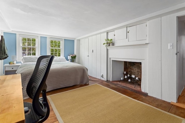 bedroom with light wood-style floors and a fireplace