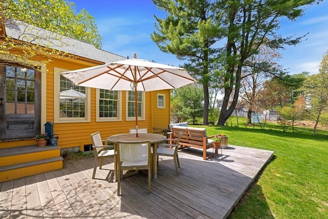 deck featuring a lawn and outdoor dining space