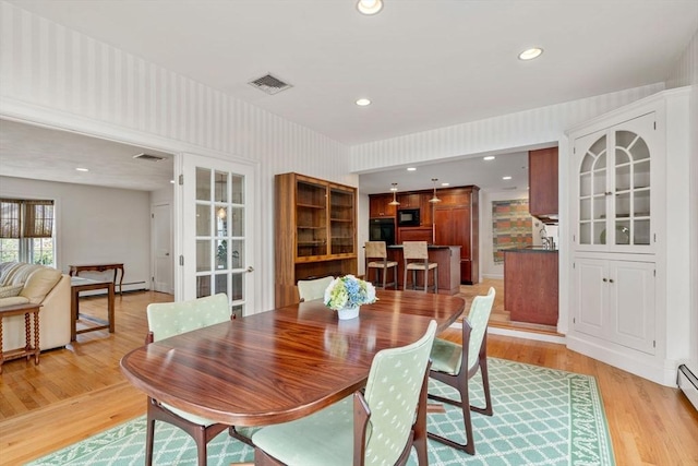 dining area featuring recessed lighting, visible vents, light wood-style flooring, baseboard heating, and wallpapered walls