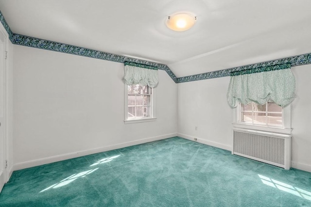 spare room featuring radiator, baseboards, carpet floors, and lofted ceiling