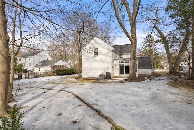 view of side of home with central AC and fence