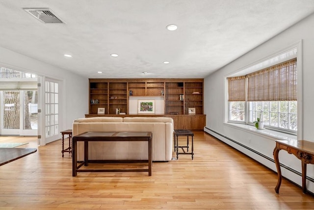 living area featuring light wood-type flooring, a baseboard heating unit, visible vents, and recessed lighting