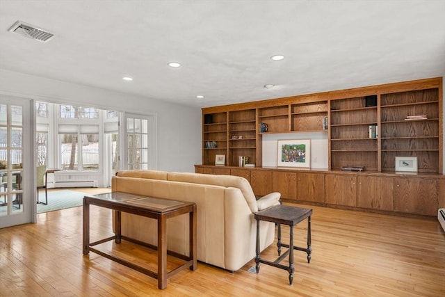 living area with a baseboard heating unit, recessed lighting, visible vents, and light wood-style floors