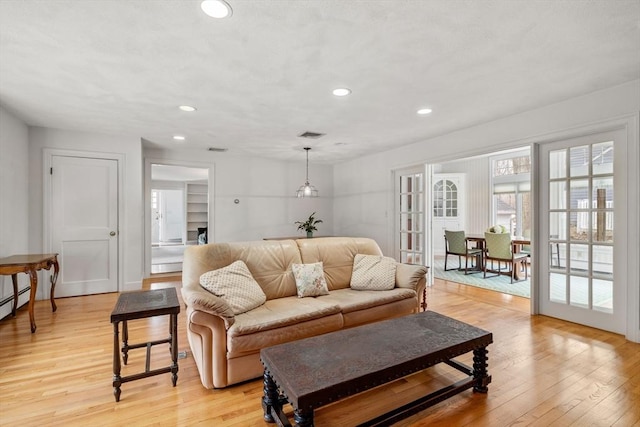 living room featuring light wood-type flooring, visible vents, french doors, and recessed lighting