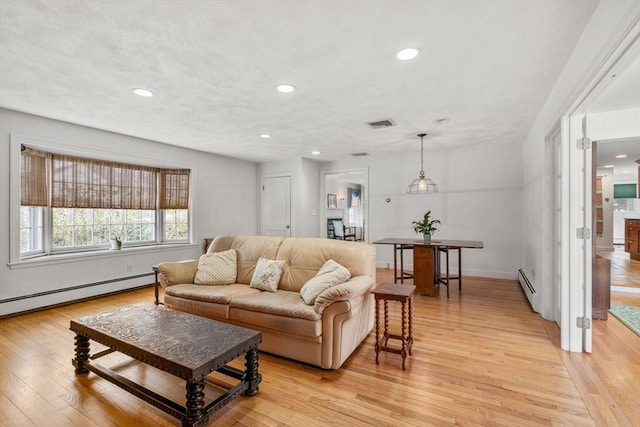 living area featuring light wood-style flooring, visible vents, baseboard heating, and recessed lighting