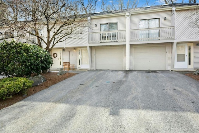 townhome / multi-family property featuring a balcony, a garage, and driveway