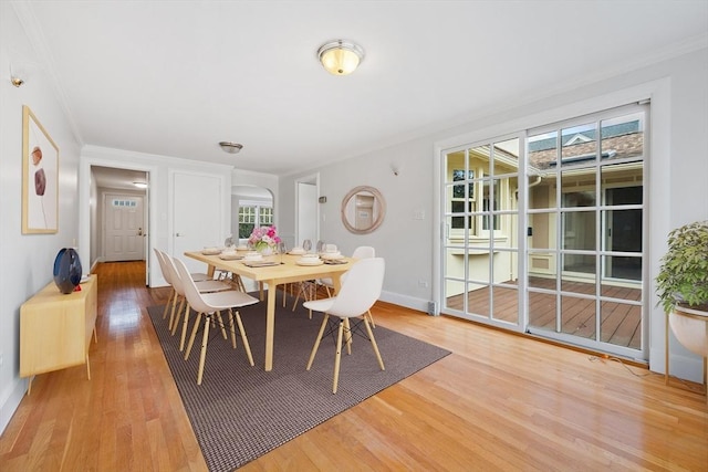 dining room featuring crown molding, a healthy amount of sunlight, and wood finished floors