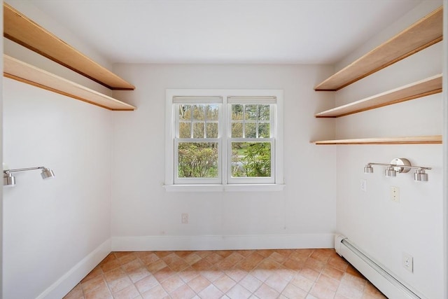 laundry room with baseboards, laundry area, and a baseboard heating unit