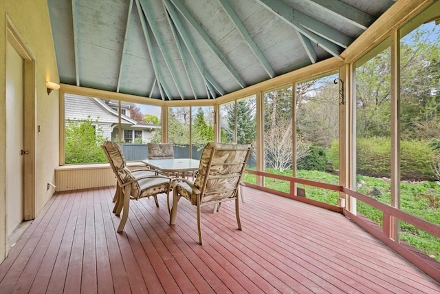 sunroom / solarium with beam ceiling and outdoor dining space