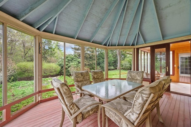 sunroom featuring outdoor dining space and beamed ceiling