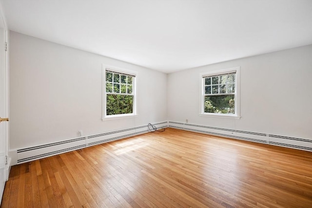 unfurnished room featuring a baseboard radiator and hardwood / wood-style floors