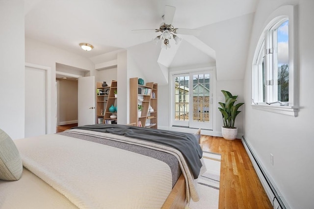 bedroom featuring a ceiling fan, baseboards, wood finished floors, lofted ceiling, and a baseboard radiator