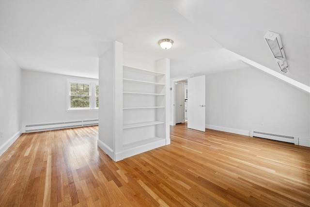 bonus room featuring wood finished floors, baseboards, built in features, and a baseboard heating unit