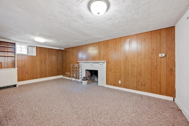 below grade area featuring wooden walls, a fireplace, carpet, and a textured ceiling