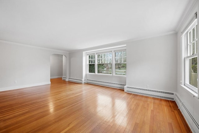 unfurnished living room featuring arched walkways, light wood finished floors, baseboard heating, and a wealth of natural light